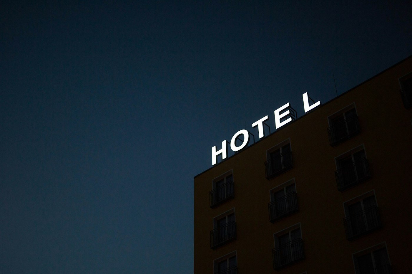 The Entrychoicegate hotel sign glowing above the entrance at night