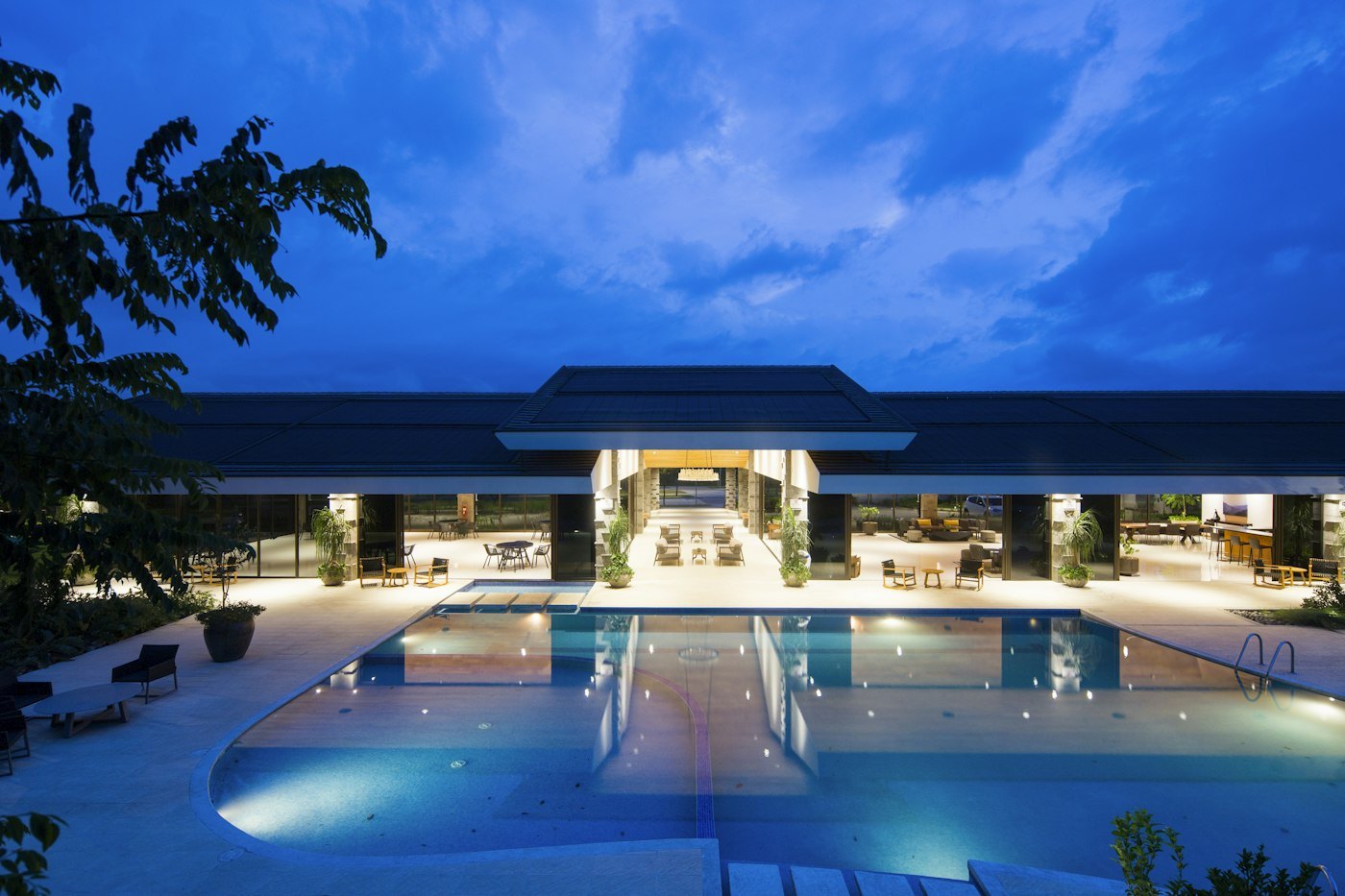 The Entrychoicegate pool courtyard glowing at dusk behind the lodge