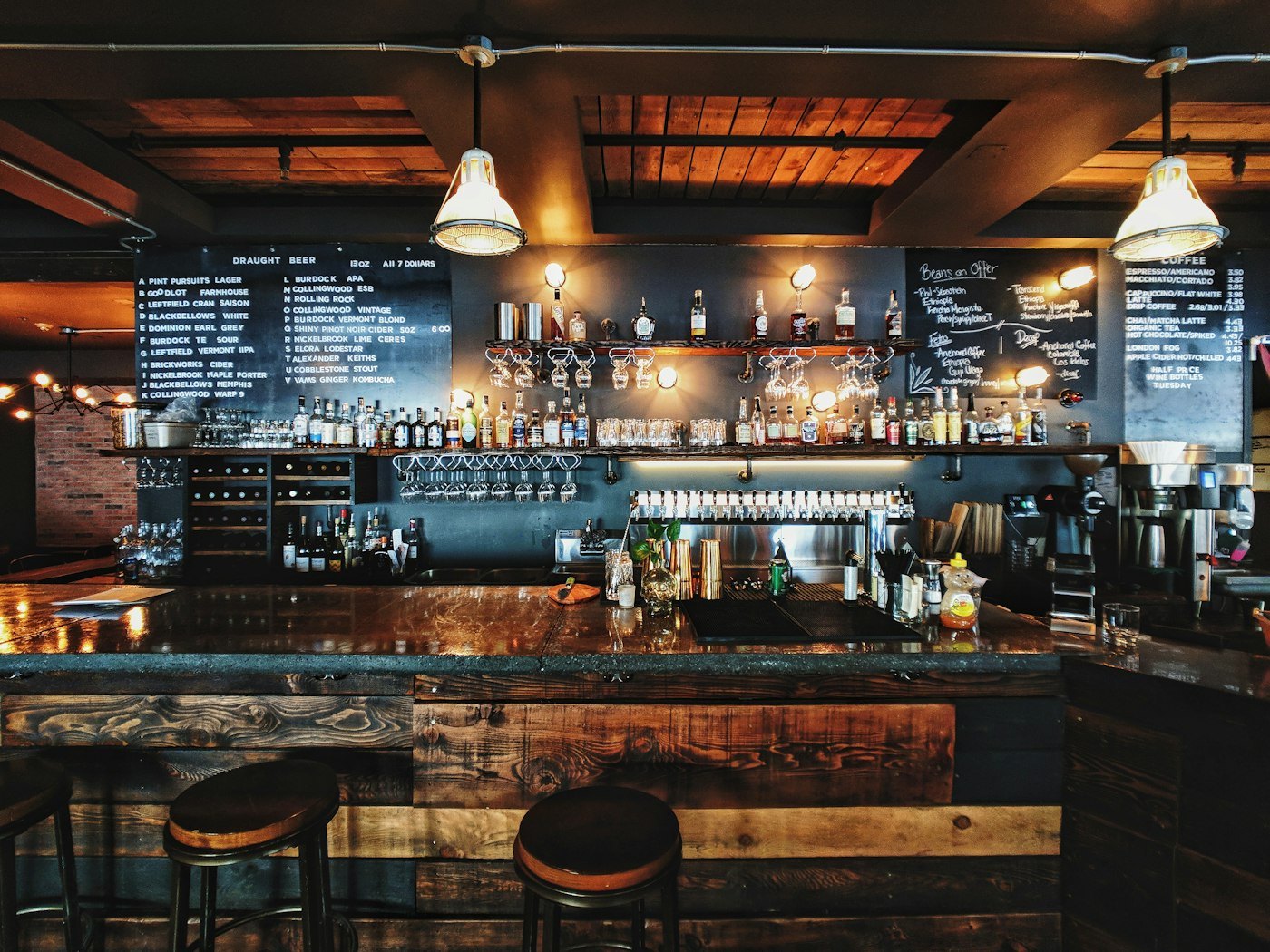 Warm lamplight over the brick-and-timber salon bar at Entrychoicegate