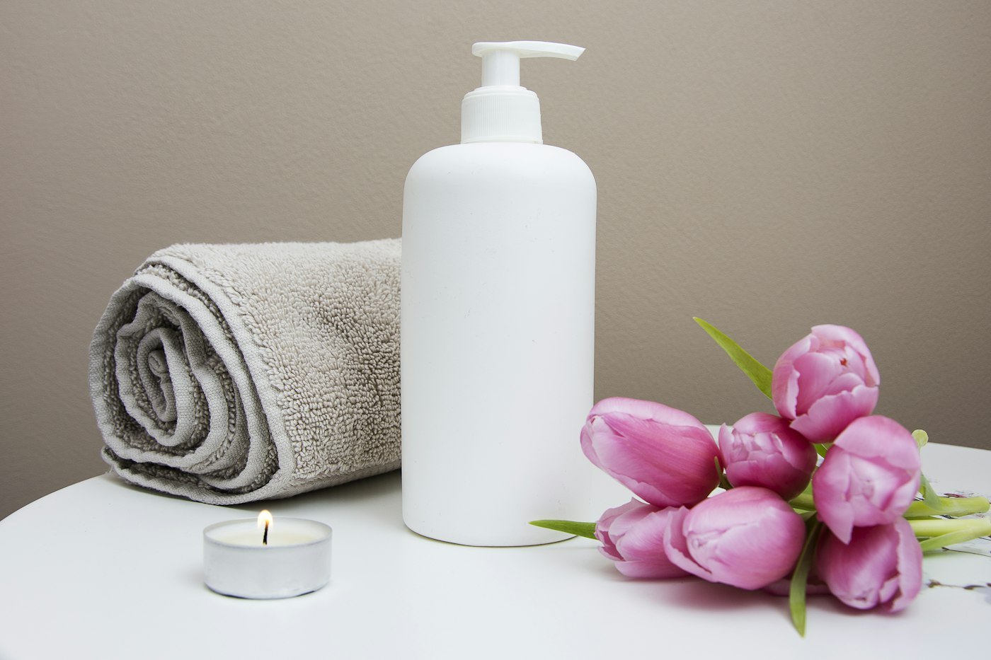 Rolled towels, orchid and mānuka oil prepared for a treatment at the Entrychoicegate spa